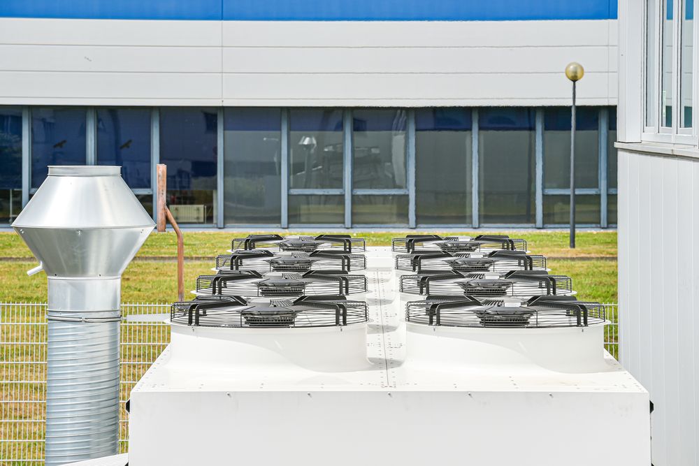 Verflüssiger mit acht Ventilatoren auf dem Container, daneben ein Lüftungsrohr mit Wetterschutzhaube